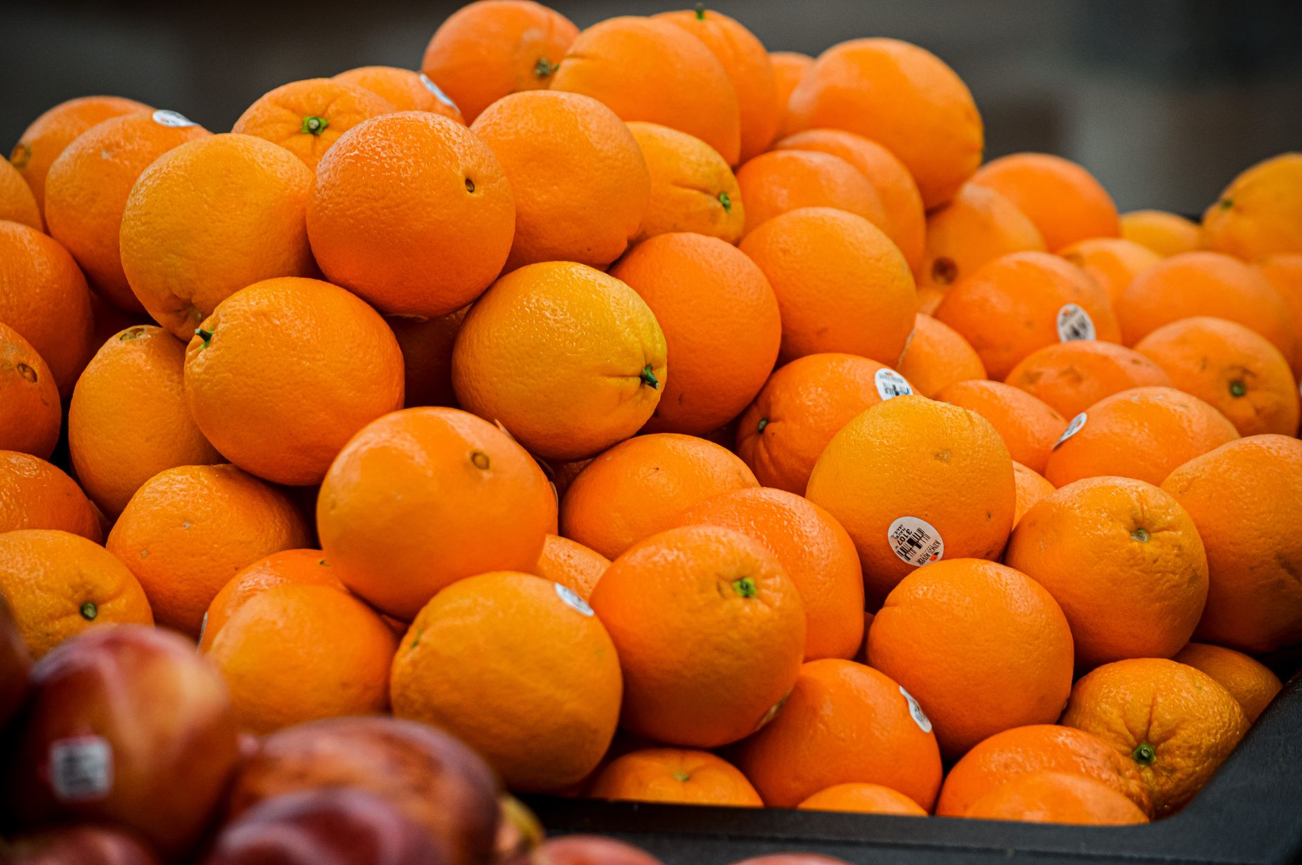 Naranjas de colores vivos apiladas en un mercado que muestra frescura y abundancia.