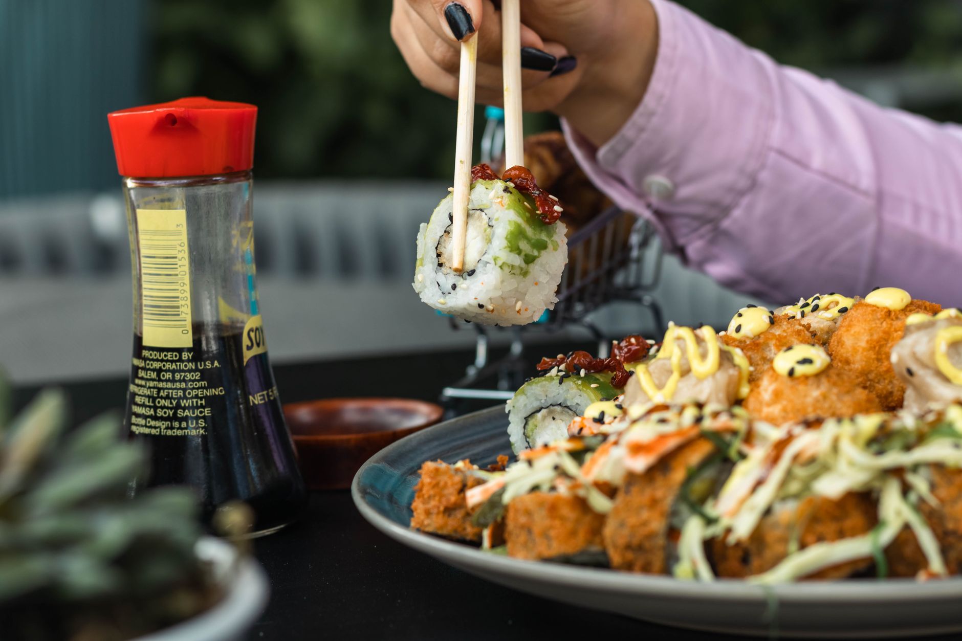 Un plato de sushi variado disfrutado con palillos en un entorno de restaurante.